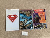 Front of three comic books: sealed Superman set, Batman issue, Walt Disney Showcase issue