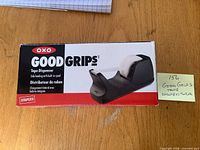 Front of boxed OXO Good Grips tape dispenser showing branding and product image