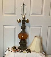 Full view of amber lamp, shade, and parts on surface