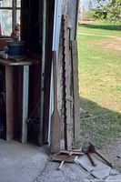 Long wooden bar clamps and paddle leaning against wall