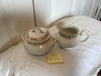 Sugar bowl and creamer side by side on table
