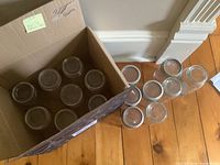 Box holding multiple quart and pint glass jars plus loose glass lids