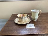 two demitasse cups and one saucer on table