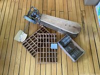 Group view showing ironing board, vent covers, jar tops in tray, churn mechanism