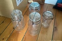All four wire-bail glass canning jars grouped together on floor