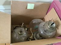 Box containing multiple glass lamp bodies and metal caps