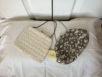 Ivory and silver beaded purses side by side on surface