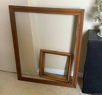 Both wood frames leaning against wall