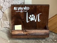 Front view of stained wood plaque showing text, pawprint graphic and shelf