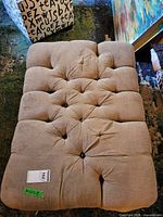 Top view showing button-tufted beige upholstery
