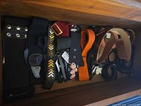 Drawer containing multiple belts of various styles and colours