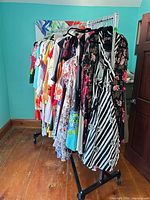 Full view of metal garment rack loaded with clothing to show structure, double rails, and casters