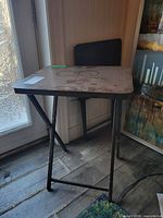 Two folding TV tray tables, one open and one folded, showing tops, legs and wear