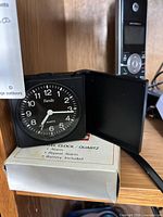 Close-up of IKEA Family folding travel clock beside Motorola handset