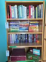 Full view of four shelves showing books and lower board games
