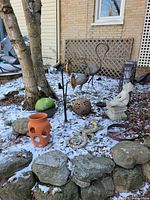 Wide view of assorted garden ornaments including statues, pots, metal sculptures and decorative spheres