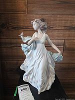 Front view of Lladro Summer Serenade porcelain figurine on display stand