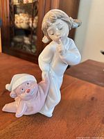 Front view of Nao porcelain figurine showing girl and elf doll