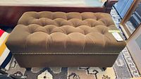 overall view of brown tufted ottoman bench
