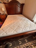 Full view of bed showing headboard, frame, drawers at footboard