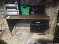 Front view of desk showing laminate top, two-drawer metal pedestal, open knee space