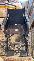 Front view of black Drive manual wheelchair showing frame, seat, backrest, armrests, footrests, wheels