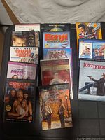 All 13 DVD cases displayed on flat surface showing front cover artwork, including Cheaper By The Dozen 2, Mean Girls, Coyote Ugly, Princess Diaries 2, Benji: Off The Leash, Bolt, When Harry Met Sally and Justified Season 3 box set