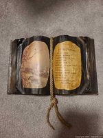 Open-book plaque laid flat showing image and poem