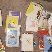Group of assorted greeting cards and envelopes spread on carpet