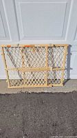 Front view of adjustable wooden lattice baby gate folded