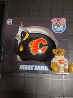 Box front showing piggy bank and teddy bear through window