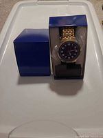 Watch in open blue Casio box on plastic stand