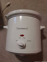 Front view of Continental Electric white slow cooker showing control dial and branding