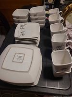 Stacked dinner plates, bowls and mugs showing pattern and quantity