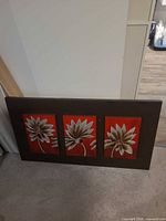 Front view of wall panel showing three floral sections within brown frame