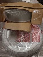 Light fixture inside opened carton showing frosted glass shade and packaging