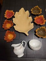 Full lot showing beige leaf platter, six coloured leaf bowls, Snowhite Regency creamer and sugar