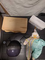 All four items visible: iHome alarm clock with cord, wooden jewelry box, plush clown, boxed cleaner