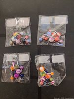 Four sealed plastic packs each containing five multicolour belly button rings