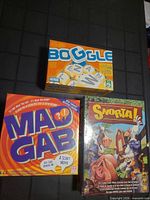 Three boxed games Boggle, Mad Gab, Snorta shown on table