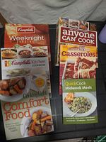 Front covers of all six cookbooks arranged on table