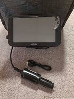 Front view of Magellan GPS with attached car charger and micro-USB cable visible
