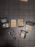 All seven makeup items laid out showing palettes, mascara, eyeliner and lip balm