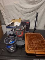 All items grouped: French press box, fondue set box, two Ninja tumblers with lids, milk frother, two Gotham Steel bacon racks, metal paper towel holder