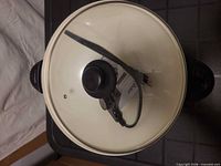 Top view showing wok with glass lid and thermostat cord placed on lid