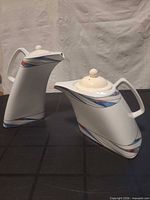 Both teapots standing to show shape and decoration