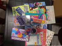 All 11 paperback puzzle and coloring books spread on table