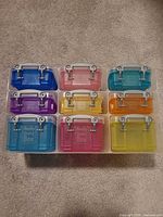 Nine multicolored Really Useful Box mini storage containers arranged in 3x3 grid