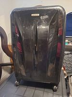 Front view of suitcase showing shell design and general wear