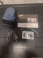 Camera front with case, manual and cable grouped